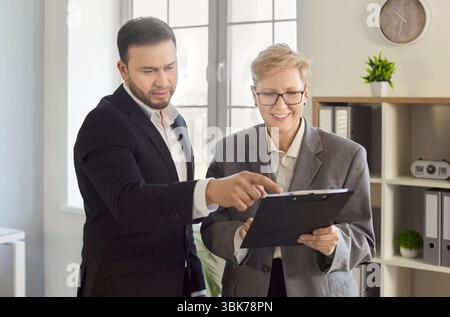 Des collègues hommes et femmes et des professionnels des affaires qui font de la paperasse au bureau Banque D'Images