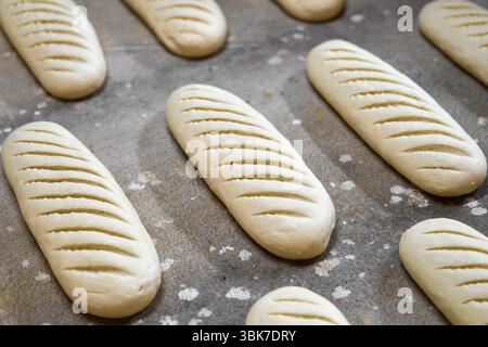 Pâte façonnée pour les pains tranchés à l'usine de boulangerie prête pour le processus de cuisson pour créer du pain frais Banque D'Images