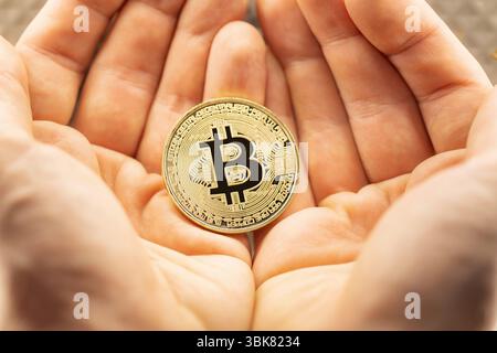 Bitcoin physique tenu dans les mains photo de gros plan Banque D'Images