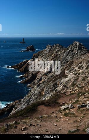 Les navires contournant le point accidenté du Raz dans le Finistère, en Bretagne, l'un des points les plus à l'ouest de la France, sont guidés à travers le canal du Raz de sein entre le continent et l'Île de sein par quatre phares largement répandus. Le chenal est connu pour ses courants atlantiques dangereux, ses vagues écrasantes et ses vents violents. Banque D'Images