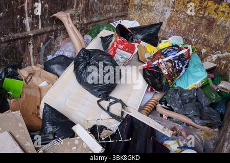 Les jambes et un bras d'un mannequin de vente au détail dépassent d'autres déchets de décharge dans une benne au centre de déchets ménagers et de recyclage de l'arrondissement de Wandsworth sur Smugglers Way, le 17 juin 2025, à Londres, en Angleterre. Les déchets mis en décharge sont l'élimination de déchets qui ne peuvent pas être réutilisés, recyclés ou valorisés, dans ou sur le sol. Banque D'Images