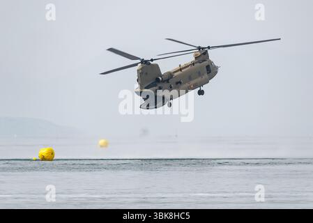 L'hélicoptère Boeing CH-47F Chinook de la Force aérienne de l'armée espagnole survolant Mar Menor à basse altitude lors du festival de l'air AIRE25 à San Javier, Murcie, Espagne. Banque D'Images