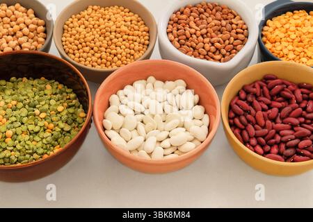 Variété de produits protéinés pour végétariens. Soja, lentilles, pois, pois chiches et divers types de haricots dans des bols. Placer pour le texte. Vue de dessus. Banque D'Images