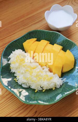 Assiette de célèbre dessert thaïlandais de mangue fraîche mûre avec riz collant et lait de coco crémeux Banque D'Images