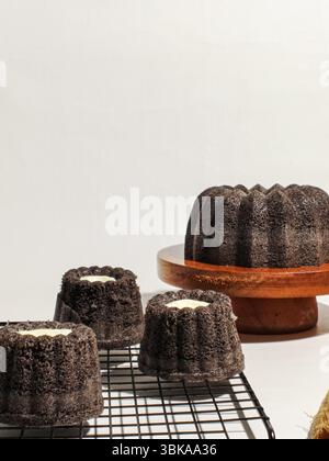 Gâteaux de riz gluant noir fraîchement préparés avec garniture au fromage, présentés sur une grille de refroidissement et une assiette blanche. Dessert indonésien maison avec moelleux et moelleux Banque D'Images