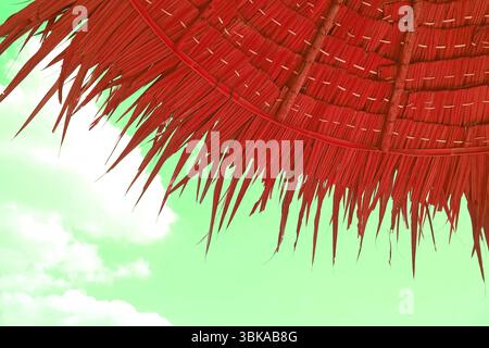 Pop Art Surreal style parapluie de plage de chaume de couleur rouge sur fond de ciel vert menthe Banque D'Images
