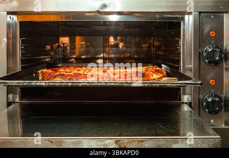 Cuisson de pizza maison dans un four électrique gros plan. Banque D'Images