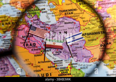 Carte de l'Iran avec les drapeaux USA, Israël et Iran sous la loupe, symbolisant la tension géopolitique et le conflit au moyen-Orient. 19 juin 2025 Banque D'Images