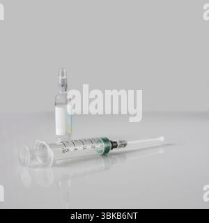Ampoule et seringue de vaccin, réflexion sur fond blanc, copie de l'emplacement, foyer sélectif Banque D'Images