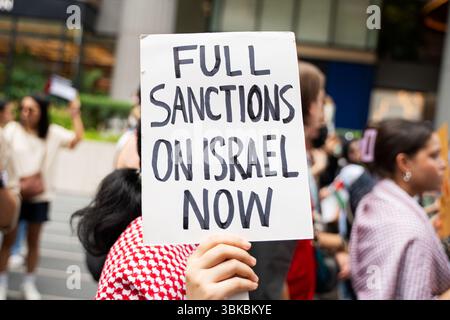 Bangkok, Thaïlande. 15 juin 2025. Un manifestant tient une pancarte avec le message ''sanctions complètes contre Israël maintenant'' pendant la manifestation. Une marche de solidarité pour Gaza a eu lieu à Bangkok. Organisé par la Palestine Solidarity Campaign (PSC), l'événement a rassemblé des manifestants appelant à un cessez-le-feu, à la fin du génocide, de l'apartheid et de l'occupation, et à l'accès de l'aide humanitaire à Gaza. Les participants portaient des drapeaux palestiniens et des pancartes avec divers messages de soutien. (Crédit image : © Ploy Phutpheng/SOPA images via ZUMA Press Wire) USAGE ÉDITORIAL SEULEMENT ! Non destiné à UN USAGE commercial ! Banque D'Images