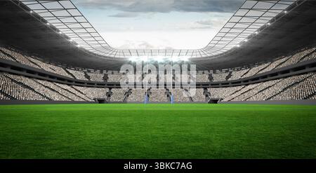 Des poteaux de but blancs de style rugby avec rembourrage bleu se dressent dans un stade plat avec terrain en herbe Banque D'Images