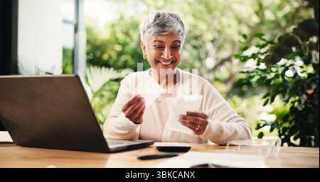Senior, femme heureuse ou ordinateur portable avec reçus pour déclaration d'impôt, déduction ou financement à la maison. Mature, femme personne et sourire avec des fiches de paie ou des factures Banque D'Images