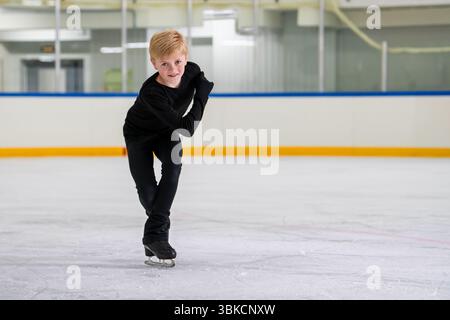 un patineur artistique garçon patine sur une patinoire intérieure Banque D'Images