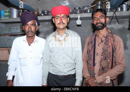 Trois générations ensemble – deux jeunes hommes et un homme âgé assis à l’extérieur Banque D'Images