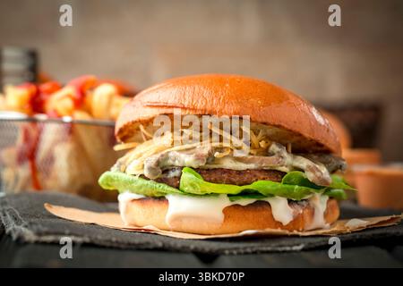 Hamburger classique avec sauce aux champignons et frites. Banque D'Images
