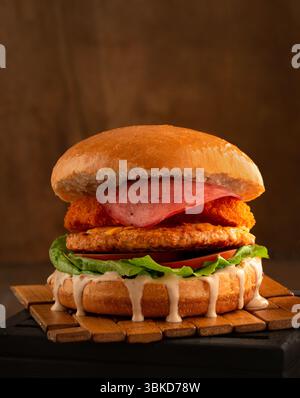 Hamburger de poulet avec sauce aux rondelles d'oignon et salami. Banque D'Images