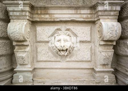 Sculpture en relief de tête de lion en pierre sur la façade d'un bâtiment vénitien historique. Le lion représente Mark l'évangéliste, saint patron de Venise. Banque D'Images
