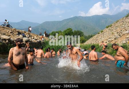 Srinagar, Inde. 20 juin 2025. Les gens se rafraîchissent dans un ruisseau pendant une chaude journée d'été dans la banlieue de Srinagar. De fortes vagues de chaleur balayent la vallée du Cachemire, poussant les températures à des sommets sans précédent dans plusieurs endroits. Le bureau météorologique local a conseillé aux résidents d’éviter les activités de plein air pendant les heures de pointe, de rester hydratés et de prendre les précautions nécessaires pour faire face à la canicule en cours. Crédit : SOPA images Limited/Alamy Live News Banque D'Images