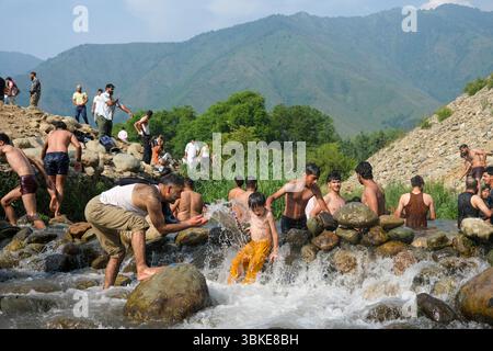 Srinagar, Inde. 20 juin 2025. Les gens se rafraîchissent dans un ruisseau pendant une chaude journée d'été dans la banlieue de Srinagar. De fortes vagues de chaleur balayent la vallée du Cachemire, poussant les températures à des sommets sans précédent dans plusieurs endroits. Le bureau météorologique local a conseillé aux résidents d’éviter les activités de plein air pendant les heures de pointe, de rester hydratés et de prendre les précautions nécessaires pour faire face à la canicule en cours. Crédit : SOPA images Limited/Alamy Live News Banque D'Images