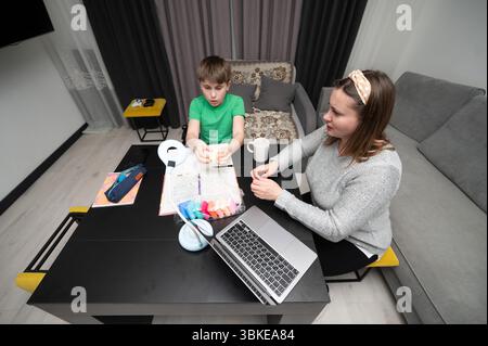 Séance d'art engageante à la maison entre un enfant et un adulte attentionné lors d'un après-midi confortable avec des activités créatives axées sur l'artisanat et l'apprentissage ensemble Banque D'Images