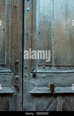 Les portes en bois vieilli présentent des textures complexes et des détails vieillis dans un vieux bâtiment. Auvergne, France Banque D'Images