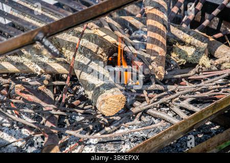 Allumer un feu pour un barbecue extérieur. Commencer un barbecue au charbon de bois avec du bois et du Kindling. Banque D'Images