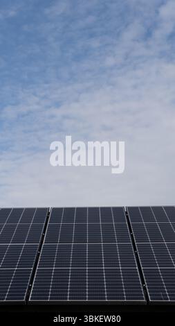 Vue rapprochée à faible angle des panneaux solaires photovoltaïques générant de l'énergie renouvelable et de l'électricité pour les maisons et les entreprises domestiques avec espace de copie au-dessus Banque D'Images