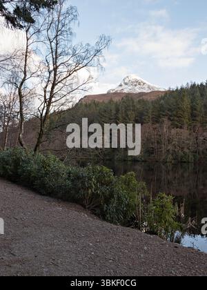 Vue depuis le chemin autour de Glencoe Lochan à Sgorr na Ciche enneigée, (le Pap de Glencoe), village de Glencoe, Lochaber, Highlands écossais. Banque D'Images