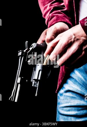 Une personne charge un revolver avec une balle. Banque D'Images