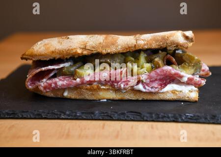 Sandwich ciabatta avec salami et concombres marinés Banque D'Images