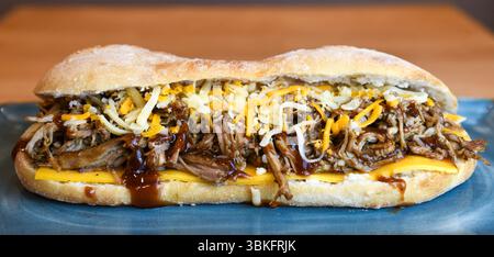 Sandwich au porc effiloché copieux avec fromage fondu et sauce barbecue Banque D'Images