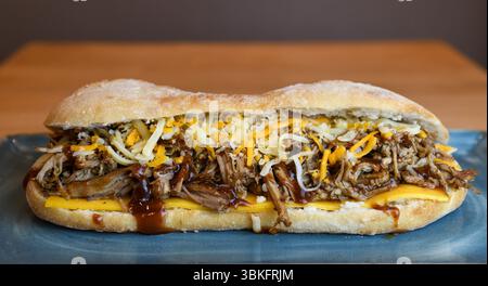 Sandwich au porc effiloché copieux avec fromage fondu et sauce barbecue Banque D'Images