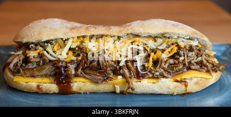 Sandwich au porc effiloché copieux avec fromage fondu et sauce barbecue Banque D'Images