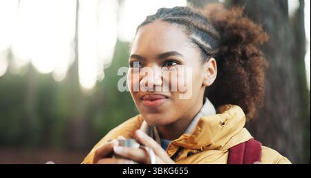 Pensée, femme africaine et randonnée en forêt avec café, idées et décision pour la destination de voyage. Personne féminine, émerveillement et planification pour Banque D'Images