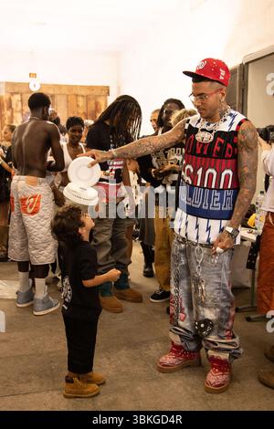 Sfera Ebbasta a été vu refroidir son fils avec un fan au défilé PDF dans les coulisses de la semaine de la mode masculine printemps/été 2026 de Milan en juin Banque D'Images