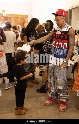 Sfera Ebbasta a été vu refroidir son fils avec un fan au défilé PDF dans les coulisses de la semaine de la mode masculine printemps/été 2026 de Milan en juin Banque D'Images
