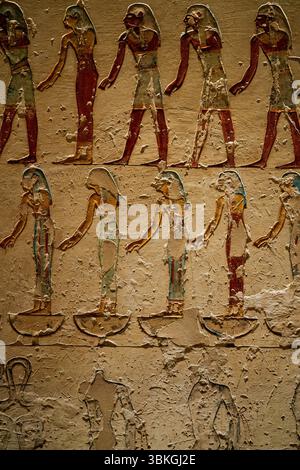 Peintures murales égyptiennes anciennes complexes avec des hiéroglyphes de la Vallée des Rois, Louxor, Égypte, mettant en valeur des couleurs vives et des figures détaillées. Banque D'Images
