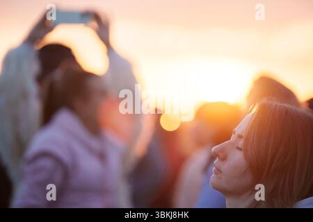 Les fêtards spirituels regardent le soleil levant et célèbrent le solstice d'été (mi-été et jour le plus long) parmi les anciennes pierres du néolithique tardif de Stonehenge, le 21 juin 2025, dans le Wiltshire, en Angleterre. Le solstice d'été est le jour le plus long de l'hémisphère nord et la nuit la plus courte de l'année, lorsque l'axe de la terre est incliné à son point le plus proche du soleil et les païens disent que l'ancien monument est un lieu sacré qui relie la Terre, la Lune, le Soleil et les saisons. Stonehenge a été construit en trois phases entre 3 000 av. J.-C. et 1 600 av. J.-C. et est maintenant la propriété de English Heritage qui dit que 25 000 visiteurs étaient Banque D'Images