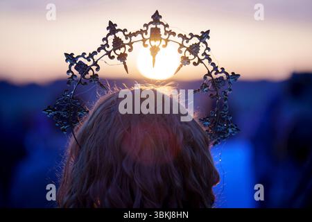 Les fêtards spirituels regardent le soleil levant et célèbrent le solstice d'été (mi-été et jour le plus long) parmi les anciennes pierres du néolithique tardif de Stonehenge, le 21 juin 2025, dans le Wiltshire, en Angleterre. Le solstice d'été est le jour le plus long de l'hémisphère nord et la nuit la plus courte de l'année, lorsque l'axe de la terre est incliné à son point le plus proche du soleil et les païens disent que l'ancien monument est un lieu sacré qui relie la Terre, la Lune, le Soleil et les saisons. Stonehenge a été construit en trois phases entre 3 000 av. J.-C. et 1 600 av. J.-C. et est maintenant la propriété de English Heritage qui dit que 25 000 visiteurs étaient Banque D'Images