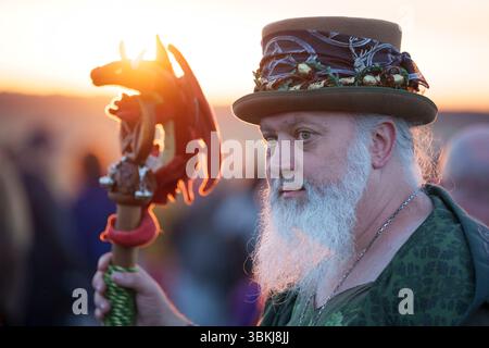 Les fêtards spirituels regardent le soleil levant et célèbrent le solstice d'été (mi-été et jour le plus long) parmi les anciennes pierres du néolithique tardif de Stonehenge, le 21 juin 2025, dans le Wiltshire, en Angleterre. Le solstice d'été est le jour le plus long de l'hémisphère nord et la nuit la plus courte de l'année, lorsque l'axe de la terre est incliné à son point le plus proche du soleil et les païens disent que l'ancien monument est un lieu sacré qui relie la Terre, la Lune, le Soleil et les saisons. Stonehenge a été construit en trois phases entre 3 000 av. J.-C. et 1 600 av. J.-C. et est maintenant la propriété de English Heritage qui dit que 25 000 visiteurs étaient Banque D'Images