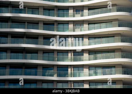 Les balcons et les fenêtres répétitifs créent un motif fascinant sur une façade de bâtiment moderne Banque D'Images