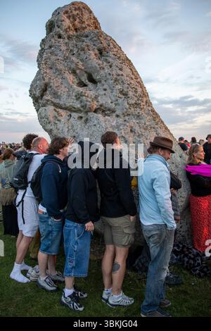 Les fêtards touchent les pierres anciennes de Stonehenge le jour le plus long. Des milliers de fêtards se sont rassemblés à Stonehenge dans le Wiltshire, en Angleterre, pour le solstice d'été annuel. Tenu dans la soirée du 20 juin et le matin du 21 juin, les néo druides, païens et non-croyants se rassemblent autour des pierres anciennes pour célébrer le lever du soleil le jour le plus long. Banque D'Images