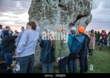 Amesbury, Salisbury, Royaume-Uni. 21 juin 2025. Les fêtards touchent les pierres anciennes de Stonehenge le jour le plus long. Des milliers de fêtards se sont rassemblés à Stonehenge dans le Wiltshire, en Angleterre, pour le solstice d'été annuel. Tenu dans la soirée du 20 juin et le matin du 21 juin, les néo druides, païens et non-croyants se rassemblent autour des pierres anciennes pour célébrer le lever du soleil le jour le plus long. (Crédit image : © James Willoughby/SOPA images via ZUMA Press Wire) USAGE ÉDITORIAL SEULEMENT ! Non destiné à UN USAGE commercial ! Banque D'Images