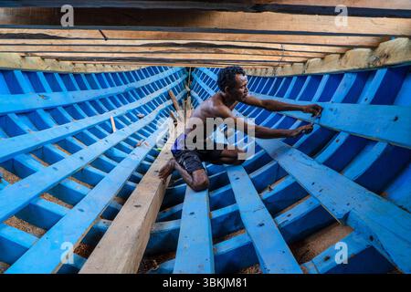 Bima, 23 novembre 2021 : un artisan qualifié de Bima assemble méticuleusement un bateau traditionnel en bois, préservant l'artisanat maritime séculaire Banque D'Images
