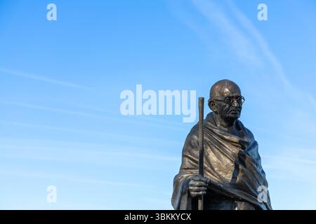 Statue solennelle du Mahatma Gandhi contre un ciel bleu vif. Symbole de paix et d'indépendance indienne. Banque D'Images