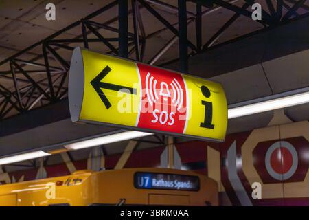 Panneau jaune et rouge indiquant la direction d'une alarme d'urgence SOS et d'un point d'information à une station de métro. Consignes de sécurité publique. Berlin, germe Banque D'Images