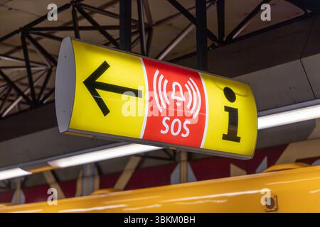 Panneau jaune et rouge indiquant la direction d'une alarme d'urgence SOS et d'un point d'information à une station de métro. Consignes de sécurité publique. Berlin, germe Banque D'Images