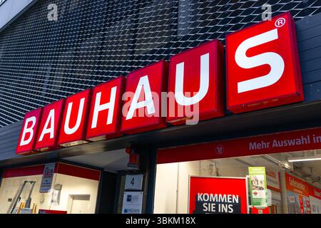 Signe de logo Bauhaus illuminé rouge sur une façade de bâtiment moderne, indiquant une amélioration de la maison ou une quincaillerie dans un cadre urbain Banque D'Images