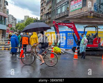 Taipei, Taïwan, foule, scène de rue, cyclisme homme avec parapluie, avant, chantier de construction, Centre-ville, personnes de groupe, hommes travaillant dans Rain Banque D'Images