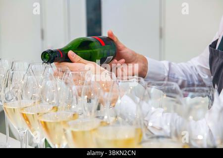 Verser du vin mousseux anglais dans des verres lors d'une fête Banque D'Images